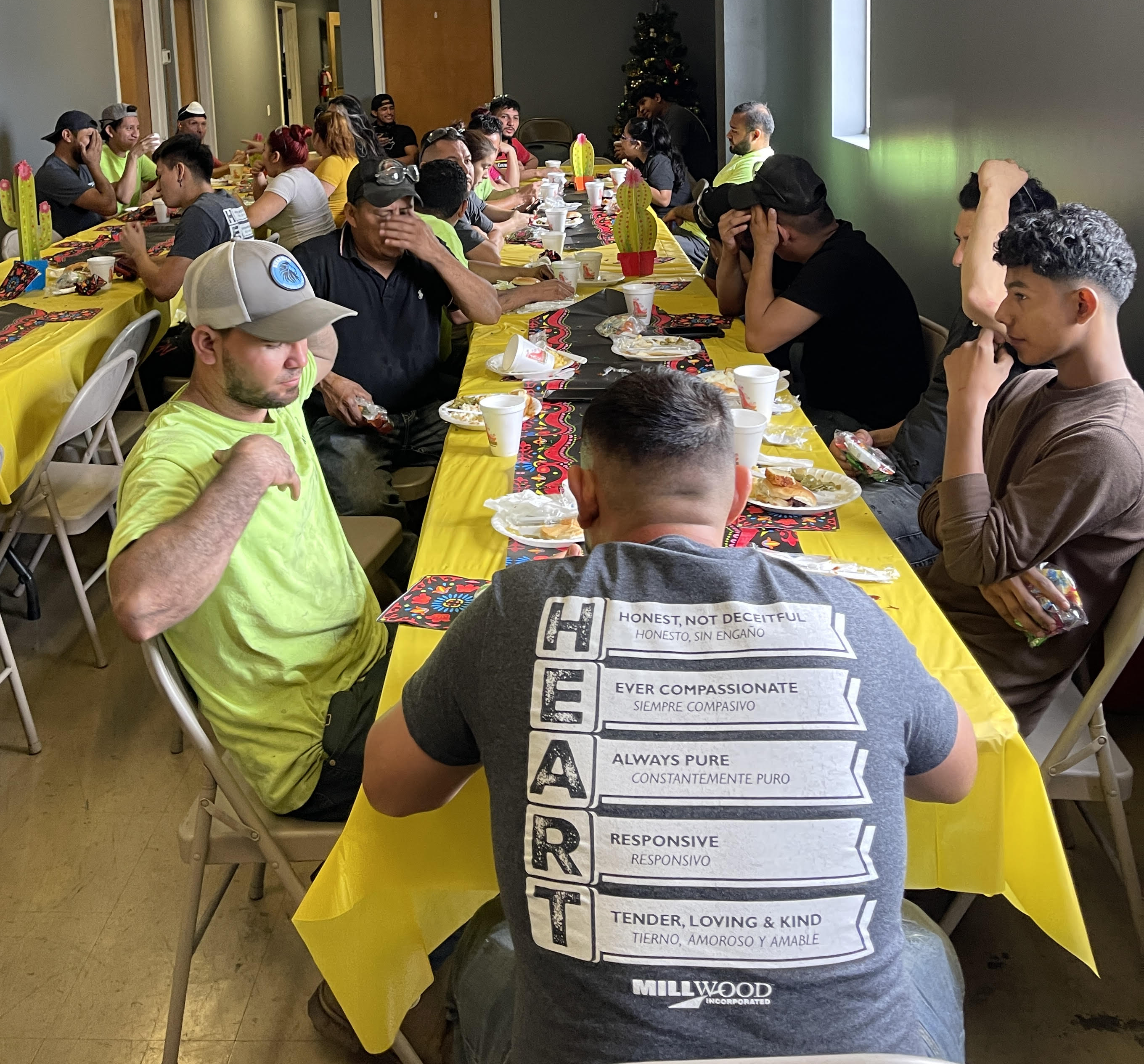 team members gathered at long tables with yellow tablecloths for their safety luncheon