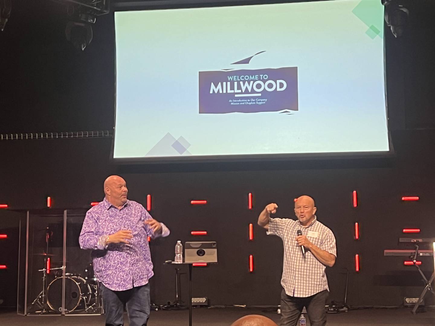 Carmine Azzato and Luis Diaz on stage with a welcome message on a screen behind them