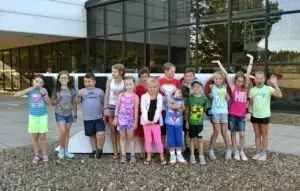 a photo of kids that ready to be send to a camp in front of millwood headquarter