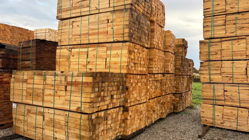 Strapped blocks of specialized Cribbing wood sitting outside in a paved lot.