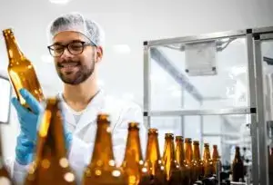 man working on glass bottling assembly line