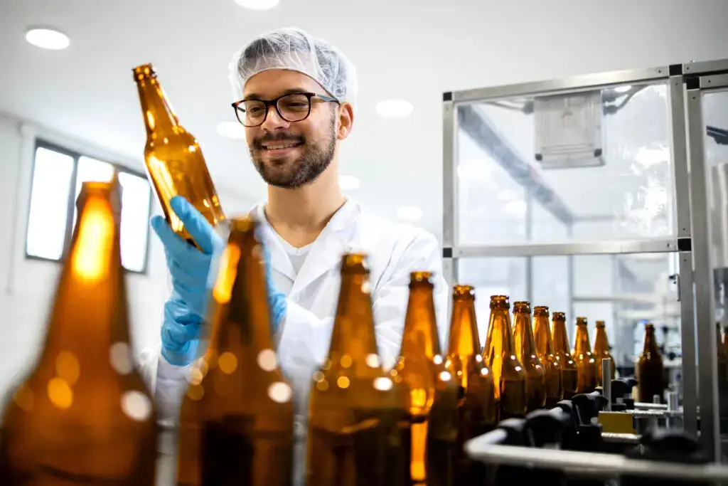 man working on glass bottling assembly line