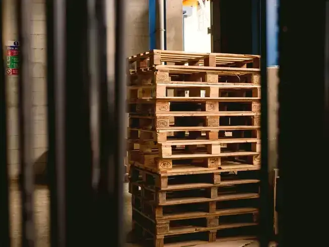 Stacked 48×40 GMA pallets in a warehouse showing standard GMA pallet size and recycled pallet supply.