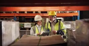 Warehouse engineers discussing sustainable packaging solutions.