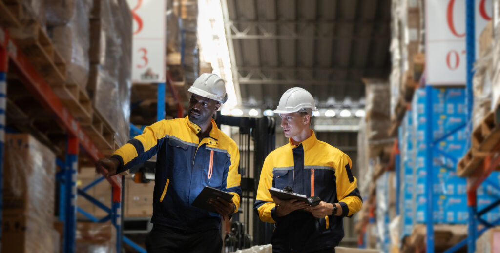 Millwood engineer reviewing custom pallet design and pallet configuration requirements with a customer in a warehouse environment.