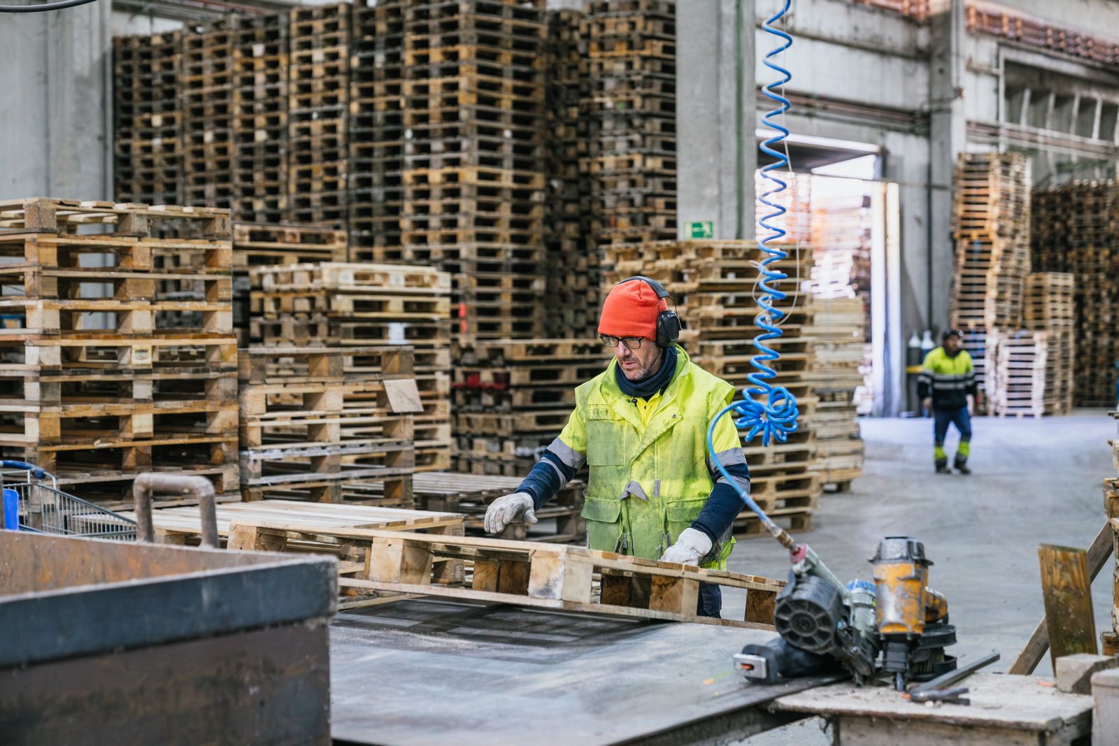 Damaged pallets being sorted and repaired through a recycled pallet recovery process.