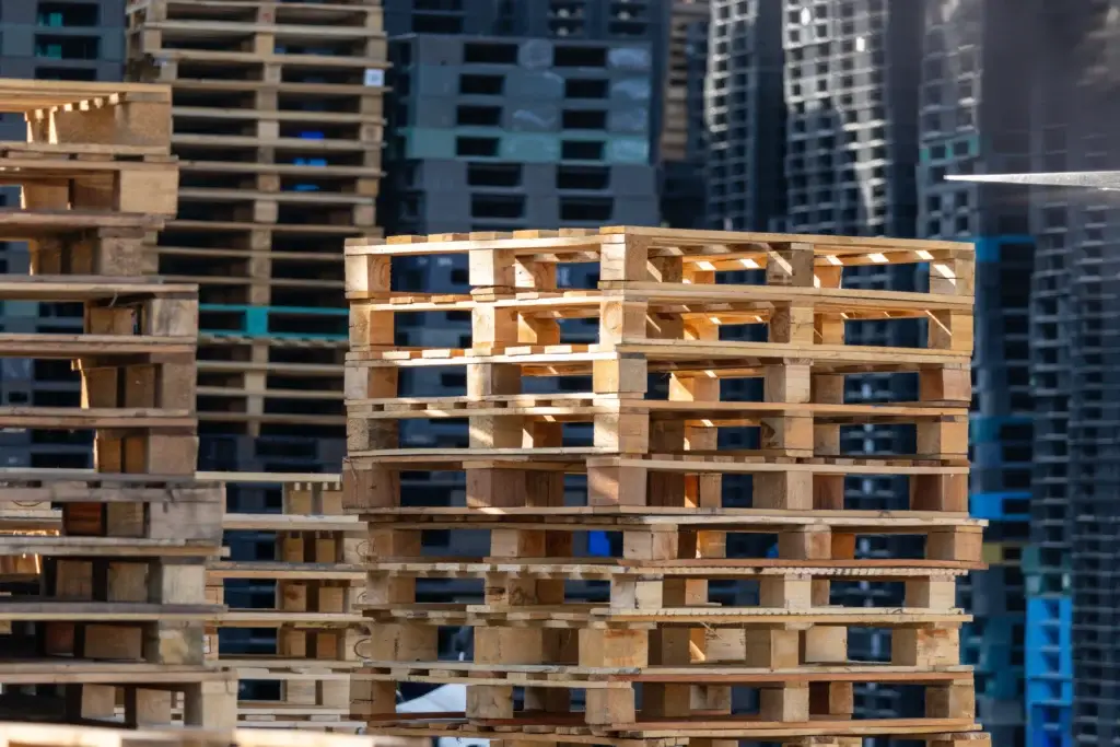 Plastic pallets vs wooden pallets used in warehouse and supply chain operations.