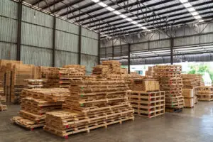Multiple wood pallets of varying sizes staged on a warehouse floor