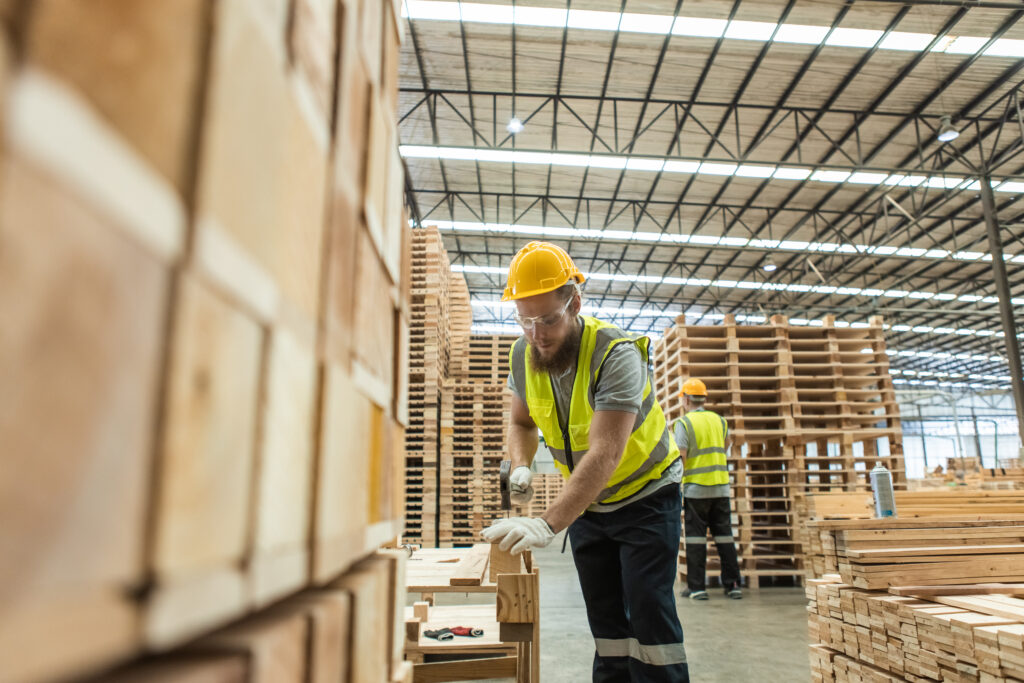 Dedicated pallet repair-and-return facility with pallets being inspected, repaired and restacked for reuse in a customer's supply chain.