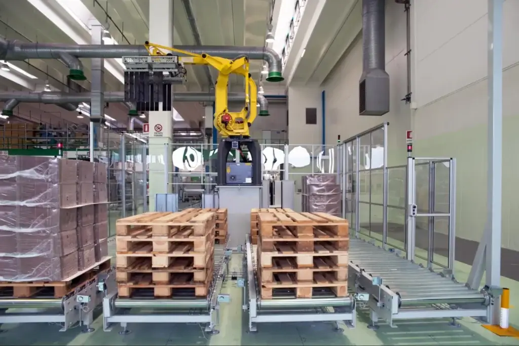Conveyor stack of graded recycled 48x40 pallets showing the standard pallet size for food and beverage industry, ready for packaging and distribution.