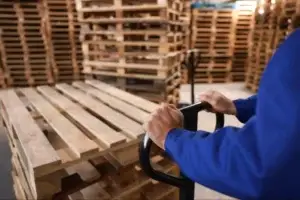 Pallet terminology guide featured image showing parts of a pallet including deck boards and stringer structure in a professional warehouse environment.