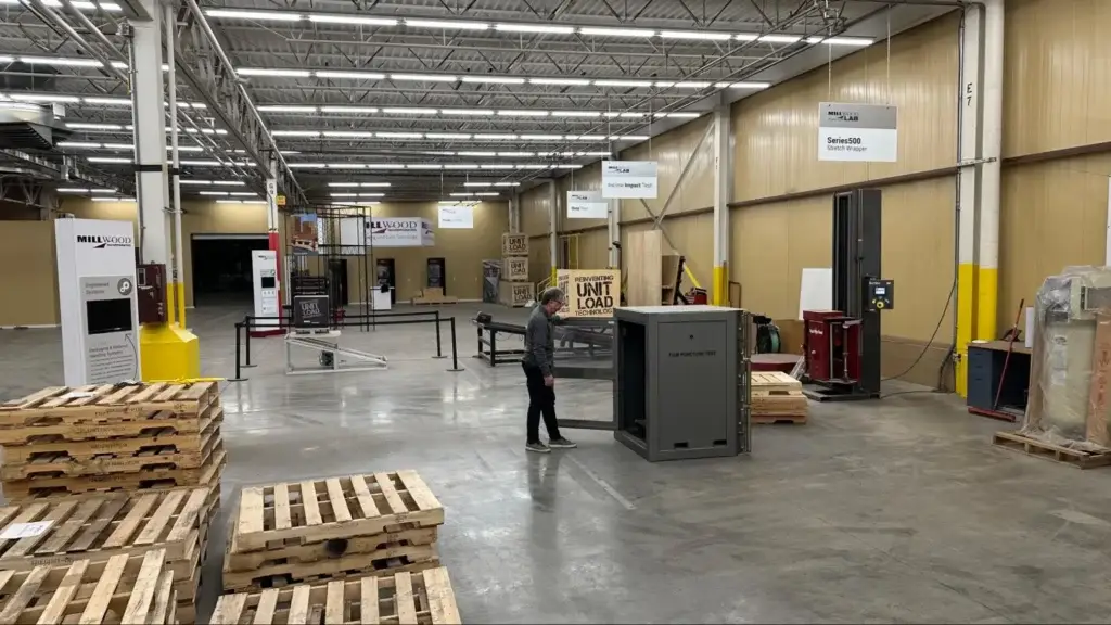 Millwood Lab technician testing stretch film punctures and unit load strength during routine packaging equipment maintenance.