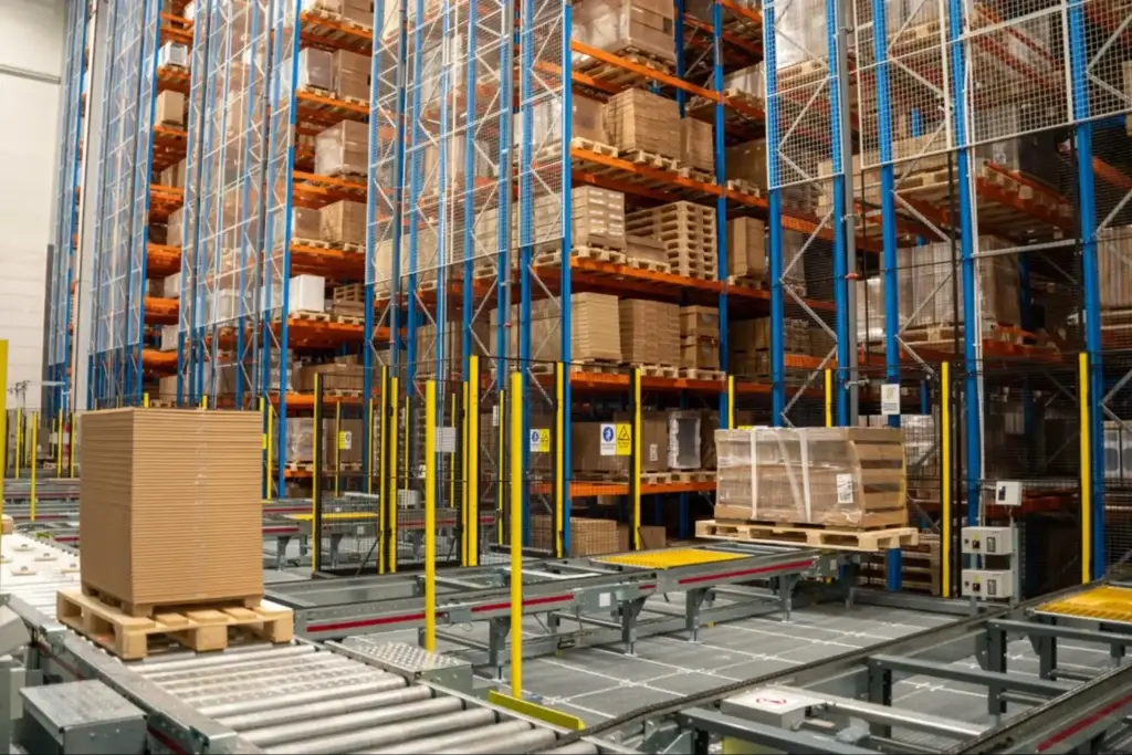 Stretch wrapped pallet loads traveling on a pallet conveyor toward an automated storage and retrieval system entry point.